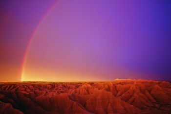 An evening rainbow begins to form over the Badlands. Click to enlarge photos.