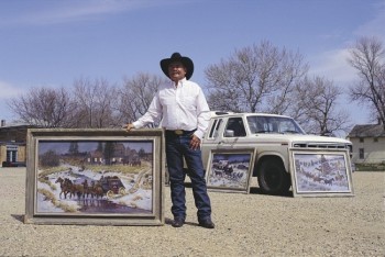 Galen Wallum displays a few of the paintings he pulled out of his pickup trailer.