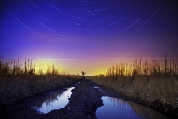 Star trails and lights from an airplane streaked over a muddy road in Minnehaha County.