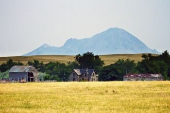 Abandoned buildings rest in the shadow of the butte a few miles northwest of the park.