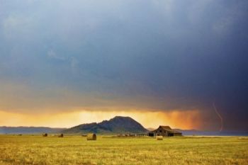 A summer thunderstorm approaches the butte from the northwest.