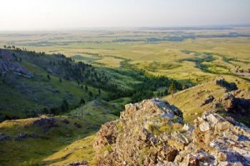 Early morning light and distant haze from nearby wildfires give an ethereal air to the prairie southeast of the butte.