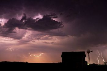 A September thunderstorm lights up the wild sky surrounding this abandoned house and windmill near Epiphany, SD.