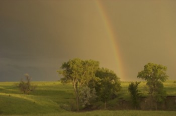 A spring storm brings promise to the growing season, as well as the fleeting beauty of a rainbow. Photo by Bernie Hunhoff.