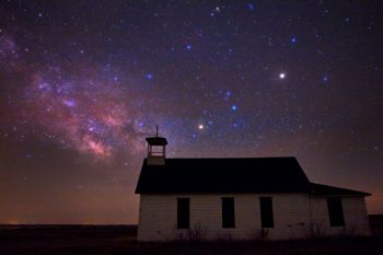 Divine Infant Catholic Church with the Milky Way. The faint haze made the brighter stars and planets appear large in the sky. The red giant star Antares is the bright one in the middle and the bright object above and to the right is Saturn.