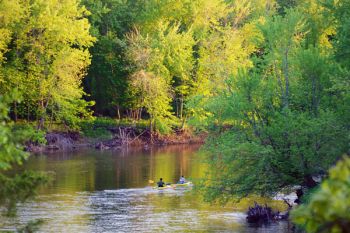 Evening light on kayakers on the Big Sioux as it winds through the woods of Big Sioux Recreation Area.