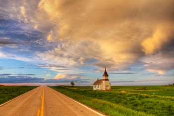 Evening light painted a passing rain cloud above historic Peace Valley Lutheran of northeast Harding County.