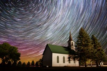 Faint aurora and star trails around the North Star provide for a unique background over historic Telemarken Lutheran Church.