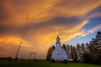 The setting sun lighting a building storm cloud near Pleasant Hill Chapel in rural Union County.