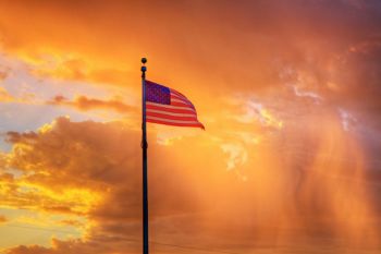 Old glory flying in the cemetery of River Bend Church with the rain shaft as a background.