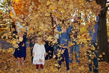 The grandchildren of Gordon and Margeret Johnson (rural Clay County) having fun with fallen leaves at Union Grove State Park.