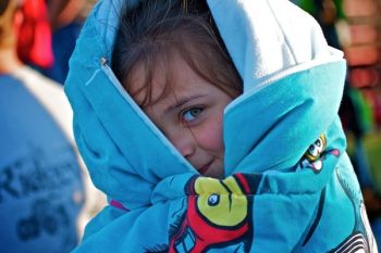 Saige Lessman playfully looking out from her sleeping bag before the rodeo starts.