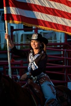 Miss Rodeo South Dakota, Kristina Maddocks, and the American flag kick off the rodeo.