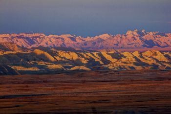 The first light of dawn hits the badlands formations.