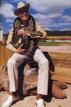 Earl Brockelsby, founder of Reptile Gardens, poses with a giant tortoise and an eight-foot python.