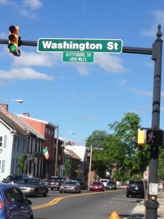 The street sign reads 'Gettysburg SD, 1,410 Miles.' The two towns are closer by heart than by highway.