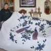 Janet Holland displays her birthday quilt. Photo by Donna Palmlund.