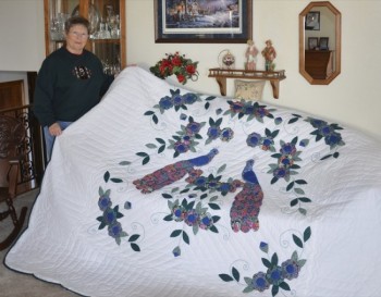 Janet Holland displays her birthday quilt. Photo by Donna Palmlund.