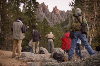 A group of photographers captures sunrise on the Cathedral Spires in Custer State Park during a photo workshop.