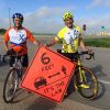 The author (left) and his legislative colleague Rep. Fred Deutsch took part in the Ride Across South Dakota (RASDAK). Their banner promotes South Dakota s new bicycling law.