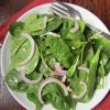 Spinach is a tough plant, but its leaves make a light and simple salad with red onion tossed in a vinaigrette.