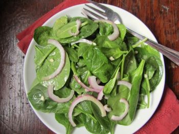 Spinach is a tough plant, but its leaves make a light and simple salad with red onion tossed in a vinaigrette.