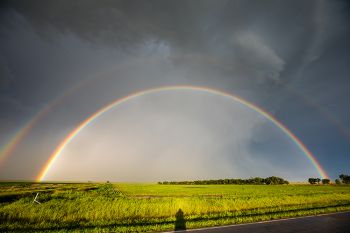 Double rainbow with the photographer’s shadow.