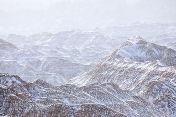 Sunlight breaking through a winter flurry at Badlands National Park in full color.