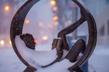 A snowy blanket seemed to adorn the young girl reading her book in the sculpture in front of the Orpheum Theater.