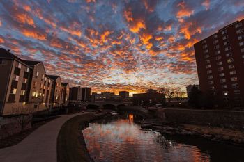 Sunset colored clouds over the Big Sioux River in downtown Sioux Falls.