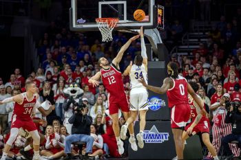 USD’s Hunter Goodrick and SDSU’s Alex Arians caught in mid-air with the whole Yote student section looking on.