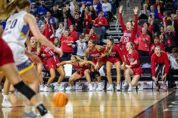 USD women’s basketball bench celebrating a big shot.