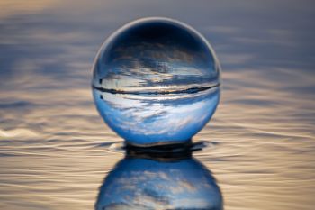 The lens ball capturing the sky above pooling meltwater at Lake Vermillion.