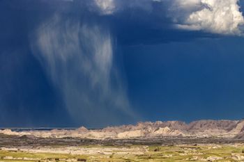 Sunlight highlighting a shaft of rain as it dances away to the northeast.