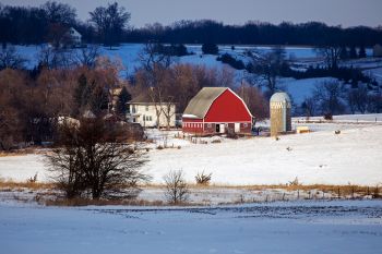 A red barn in a patch of sunlight, rural Lincoln County.