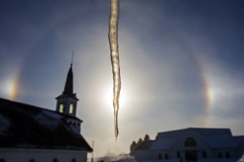 Icicle from the pioneer cabin with Old Nidaros replica’s steeple and sun dogs.