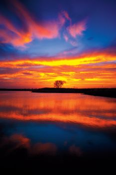 A blazing sunset reflects off a small lake in Aurora County.